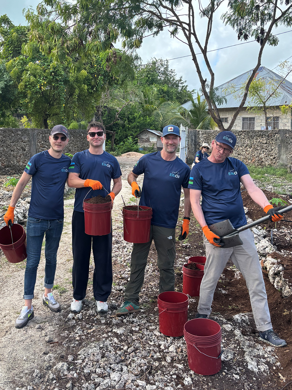 Harro Booth and ElbOil team members working in a community garden during the Zanzibar Impact Trip, supporting sustainable development and local food initiatives.